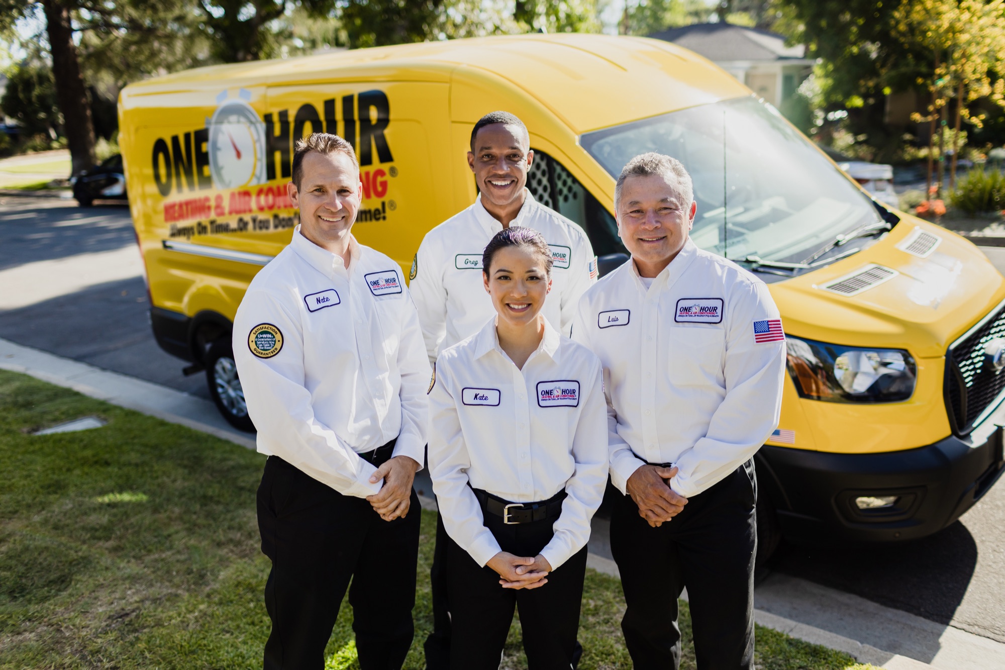 Northern One Hour Heating & Air Conditioning technicians standing in front of a branded service van